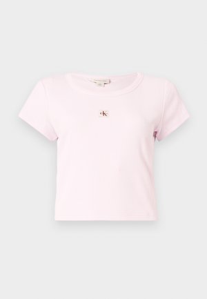 Camiseta corta de manga corta acanalada en rosa claro con cuello redondo y pequeño parche con el logo de Calvin Klein en el centro del pecho.
