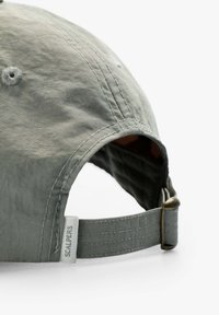 Graue Baumwollmütze mit gebogenem Schirm, mit Stickdetails und einem Metallverschluss. Enthält ein kleines Etikett mit dem Markennamen.