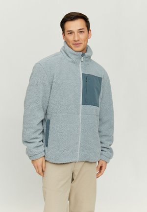 Fleece jacket in light grey with a high collar, zip closure, and a dark grey chest pocket. Features side pockets and textured fabric.