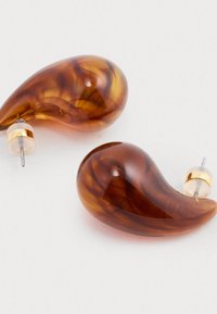 Brązowe kolczyki w kształcie kropli wykonane z żywicy, z złotymi dodatkami i przezroczystymi akcentami, ukazujące marmurkowy wzór i gładką teksturę.