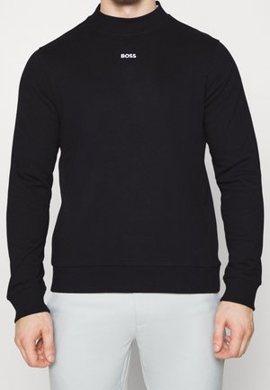 Black sweatshirt featuring a high neck, long sleeves, ribbed cuffs, and a white logo at the chest. Made from a smooth, soft fabric.