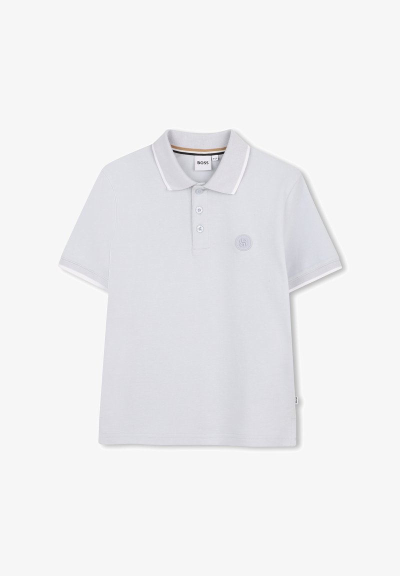 Polo blanc en tissu de coton lisse. Comprend une patte à trois boutons, un col contrastant et un petit logo brodé sur la poitrine.