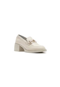Mocasines de cuero beige con puntera redondeada, correa decorativa y hebilla, y un tacón ancho. Textura suave y diseño minimalista.