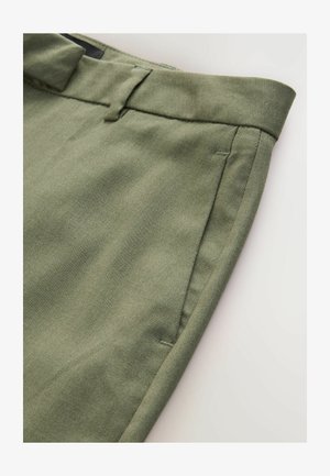 Pantaloni tagliati verde oliva con una trama liscia, dotati di fronte piatto, tasche laterali e una vita rifinita con cura.