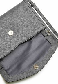 Pequeño bolso de cuero gris oscuro con cierre de botón magnético, abierto para mostrar el interior de tela gris suave y correa ajustable.