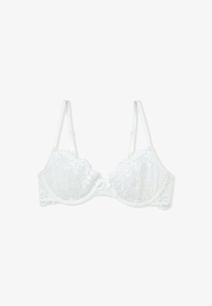 Soutien-gorge en dentelle blanche avec motif floral, soutien-gorge armature, bonnets rembourrés et bretelles réglables. Présente un accent central en forme de nœud.