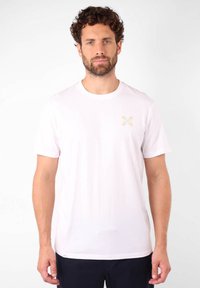 T-shirt en coton blanc à manches courtes ; présente un petit design graphique multicolore sur la poitrine gauche ; col rond.