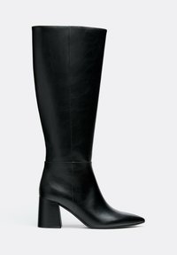 Botte noire en cuir montant jusqu’au genou, avec pointe fine et talon carré, vue de profil sur un fond clair uni.