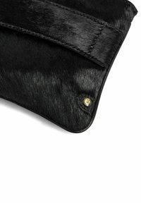 Kraftigt svart läderclutch med slät läderrem, rundade hörn och en guldstämplad logodetalj. Den strukturerade ytan skapar en visuell kontrast.