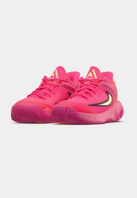 Jasnoróżowe buty sportowe z teksturowaną cholewką, zaokrąglonym noskiem i wygiętą podeszwą. Posiadają czarny znak Swooshu i żółte akcenty.