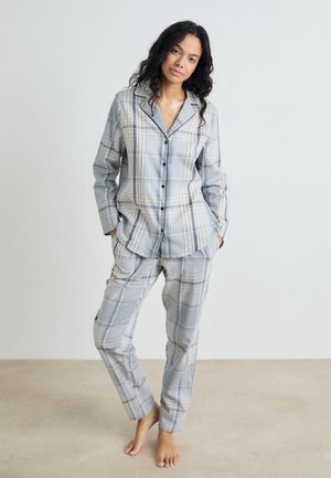 Conjunto de pijama a cuadros grises que incluye una camisa de botones con collar y mangas largas, combinada con pantalones ajustados a juego. Textura de tela suave.