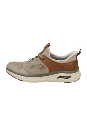 Zapatilla baja beige y marrón con parte superior de malla, detalles de cuero, suela acolchada y cierre de cordones diseñada para soporte del arco y comodidad.