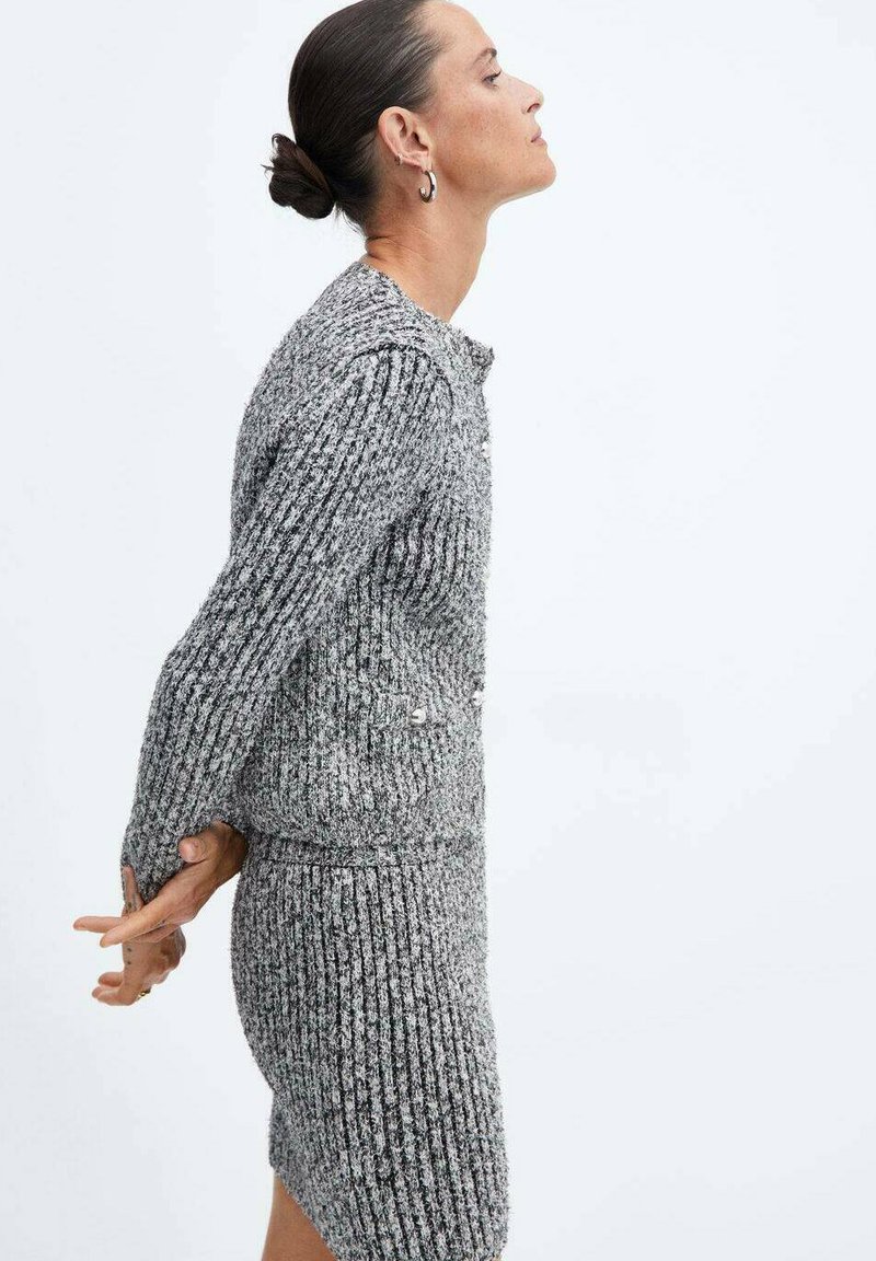 Ensemble en deux pièces en tricot côtelé gris comprenant une robe ajustée et un haut à manches longues avec un col rond et des détails de boutons.