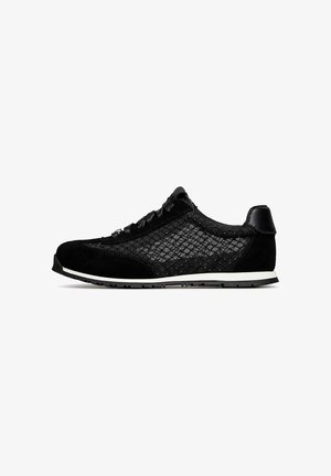 Sneaker nera basse con lati in mesh, punta e tallone in camoscio, lacci neri e suola bianca su sfondo bianco.