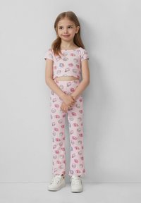 Różowy crop top i dopasowane dzwony z muszelkowym wzorem. Wykonane z miękkiego materiału, o luźnym kroju i podwiniętych rękawach.