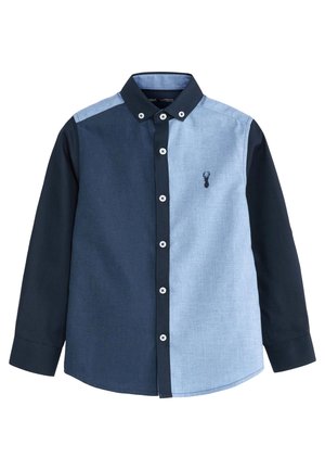 Chemise à manches longues avec panneau gauche et manche gauche bleu foncé, panneau droit bleu clair, col noir, boutons noirs et logo de cerf brodé.