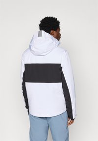 Άσπρο και μαύρο φούτερ μπουφάν με στενή εφαρμογή, που διαθέτει οριζόντια μαύρη ρίγα στην πλάτη και υφές. Λείο ύφασμα.