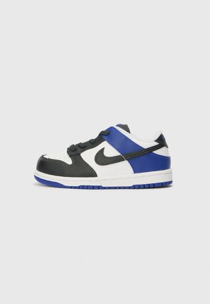 Sorte og hvide sneakers med blå detaljer. Har en runde tå, snørebånd og en struktureret gummisål. Nike-logo på siden.
