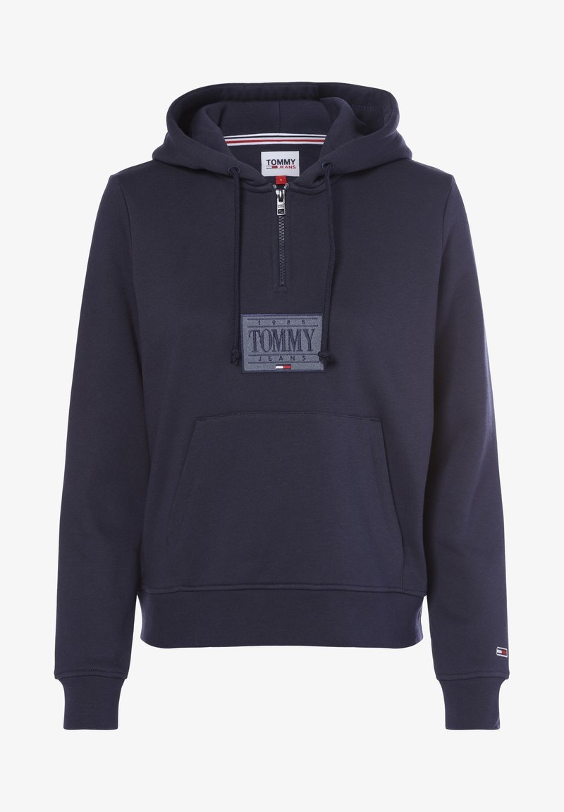Sweat à capuche bleu marine Tommy Jeans avec fermeture éclair devant, capuche avec cordon, poche kangourou et patch logo sur la poitrine et le bas des manches.