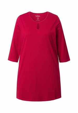 Tunique en coton rouge avec des manches trois-quarts, un col rond et un petit détail en forme de trou de serrure à l'avant. Texture lisse.