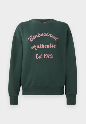 Felpa di colore verde scuro con polsini e orlo a coste, che presenta al centro un testo ricamato in rosa: "Timberland Authentic Est 1973".