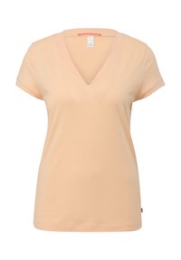 T-shirt femme à manches courtes et col en V de couleur pêche clair avec un détail de revers plié sur les manches, sur un fond blanc.