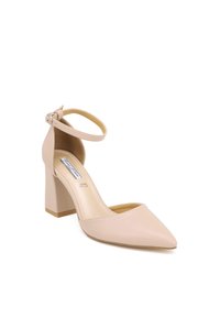 Décolleté in pelle nuda con tacco a blocco, punta affusolata e cinturino alla caviglia. Texture liscia con soletta imbottita e delicate rifiniture in oro.