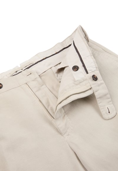 Beżowe spodnie bawełniane z suwakiem, zapięciem na guzik i kontrastową wewnętrzną taśmą w pasie. Posiadają dwie przednie kieszenie.