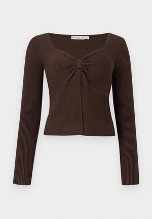 Pitkähihainen ruskea ribbineulottu paita, jossa on neliömäinen pääntie ja keskellä rintakehää kerätty solmuvivahde.