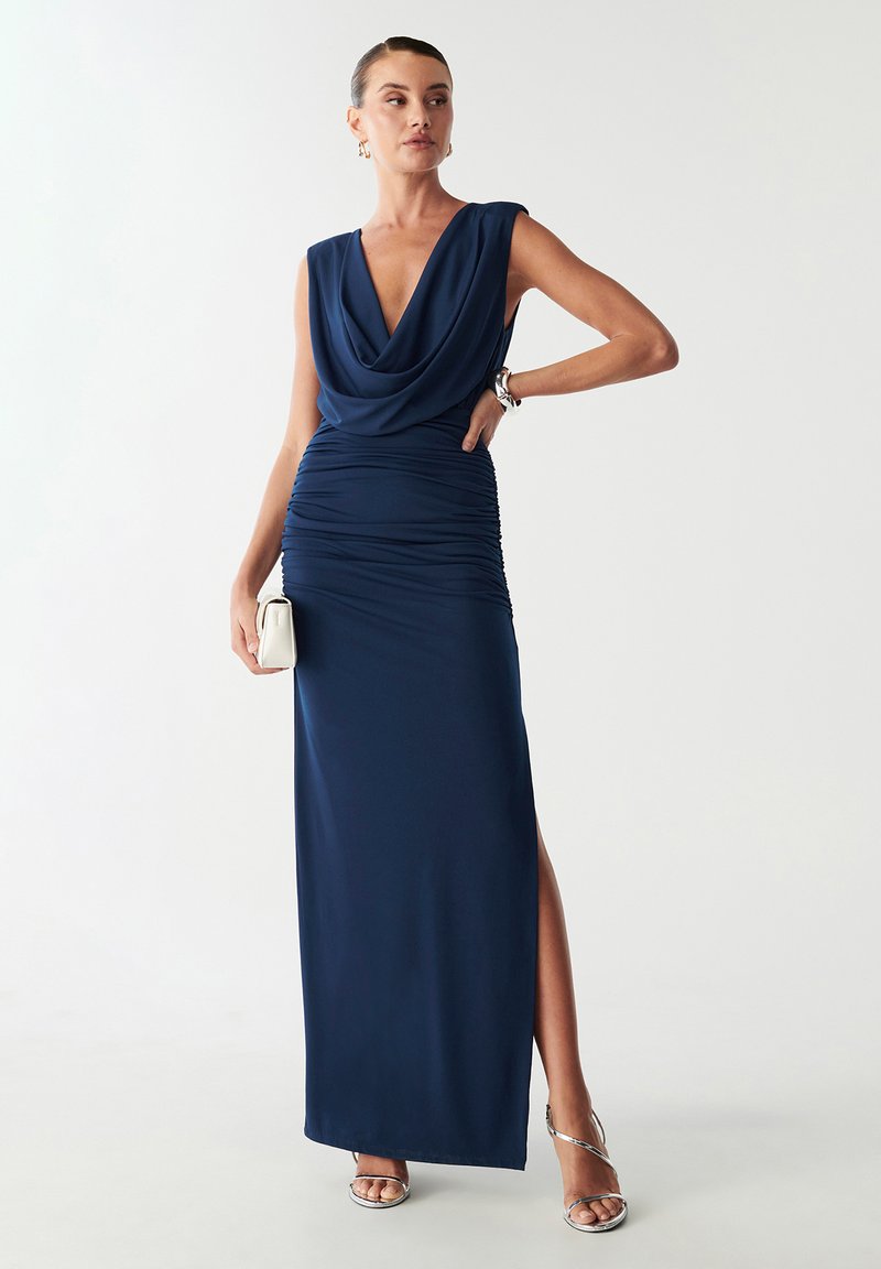 Robe longue bleu marine avec une encolure drapée, des fronces sur le côté et une fente haute sur la cuisse ; tissu lisse et extensible.