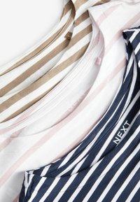 Trois t-shirts rayés de couleurs variées : blanc avec léger rose, beige avec blanc, et marine avec blanc. Tissu en coton avec encolures ras du cou.