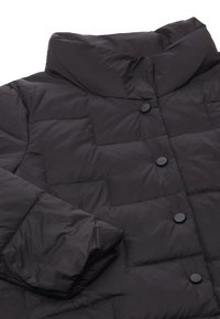 Giubbotto pom pom nero con colletto alto, caratterizzato da un design trapuntato, bottoni a pressione neri e una texture liscia e lucida.