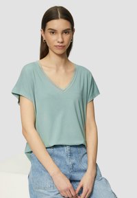 Lichtblauw V-hals t-shirt met korte mouwen en kantafwerking. Zachte, lichte stof, gecombineerd met hoge taille denim shorts.