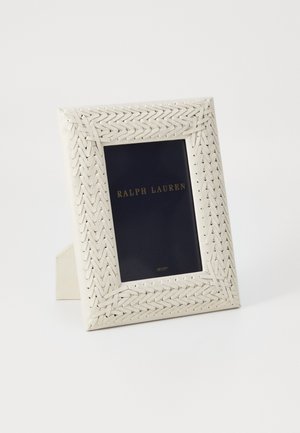 Weißer gewebter Bilderrahmen mit strukturiertem Rand und einem marineblauen Einleger, der die goldene Aufschrift "RALPH LAUREN" zeigt. Steht aufrecht.