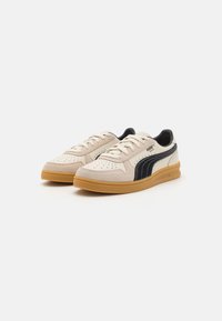 Beige Leder- und Wildledersneaker mit schwarzen Akzenten, perforierten Details und einer Sohle aus Gummigummi. Schnürdesign mit gepolstertem Kragen.