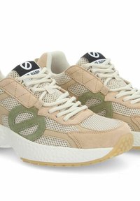 Baskets de sport en daim beige et olive avec des panneaux en mesh, dotées d'une semelle blanche épaisse et d'un logo bien visible sur la languette.
