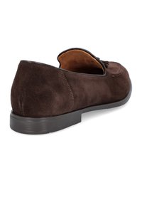 Brązowe zamszowe buty wsuwane na niskim obcasie, charakteryzujące się gładką teksturą, okrągłym noskiem oraz prostym wzornictwem. Wnętrze wyłożone jest beżową podszewką.