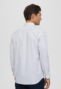 Witte button-up shirt met smalle verticale strepen in het grijs. Klassieke kraag en lange mouwen, met een gebogen zoom en verstelbare manchetten.