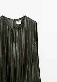 Zwarte leren mouwloze top met lange verticale franjes en een rits aan de achterkant, gelabeld "Massimo Dutti Studio."