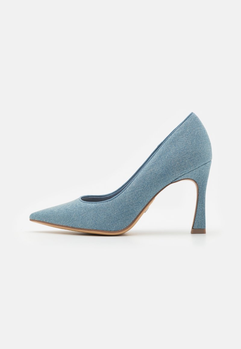 Escarpin en denim bleu clair à bout pointu avec un talon haut et fin et une semelle marron clair, présenté de profil sur fond blanc.