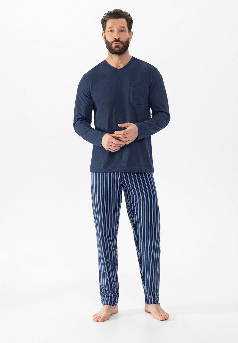 T-shirt à col V à manches longues en marine avec une poche poitrine, associé à un pantalon de pyjama à rayures verticales en marine et bleu clair. Matériau en coton, coupe décontractée.