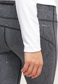 Leggings a rayas en blanco y negro con un material suave y elástico. Cuenta con una cinturilla alta y costuras reforzadas para mayor durabilidad.