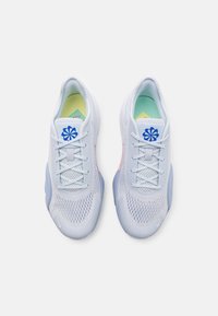 Zapatillas deportivas de color azul claro con una parte superior de malla transpirable, cordones blancos, detalles rosas en los lados y un logo azul en la lengüeta.