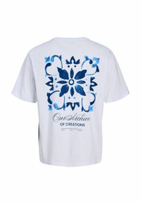 Λευκό κοντομάνικο μπλουζάκι με μεγάλο μπλε λουλουδάτο σχέδιο πλακιδίων και το κείμενο "Our Archive of Creations" στην πλάτη.