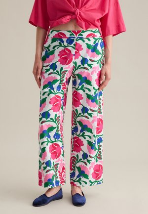 Un pantalon large à fleurs présente un fond blanc avec des motifs vibrants en rose, bleu et vert. Fabriqué en tissu léger, il offre une coupe décontractée.