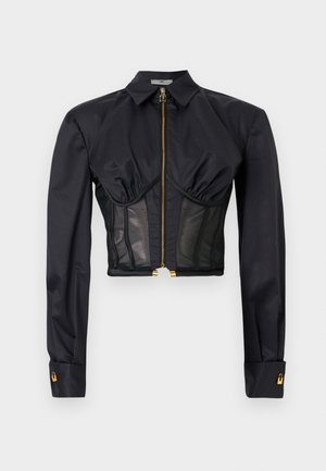 Svart långärmad cropped topp med guldig dragkedja framtill, krage, veckad byst och meshpaneler på midjeområdet.