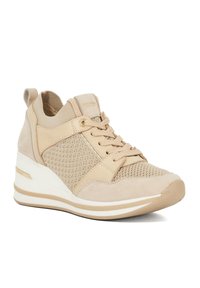 Beige sport schoen met een bovenwerk van suede en mesh, vetersluiting aan de voorkant, gewatteerde kraag en een witte tussenzool met een gouden accentstreep.