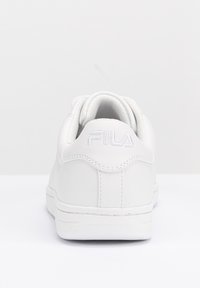 Sneaker bianco in pelle con forma arrotondata, superficie testurizzata e logo del marchio ricamato sul retro. Presenta lacci lisci e suola in gomma.