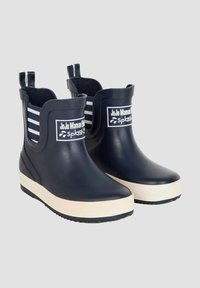 Bottes de pluie en caoutchouc bleu marine avec des panneaux élastiques rayés blancs, un patch logo blanc et une semelle texturée ; conçues pour être imperméables.