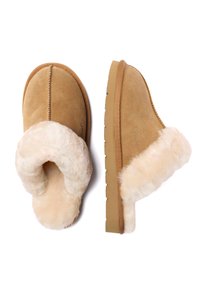 Tan suede slippers with a creamy faux fur lining, open back design, and textured rubber sole. Features visible stitching along the edges.